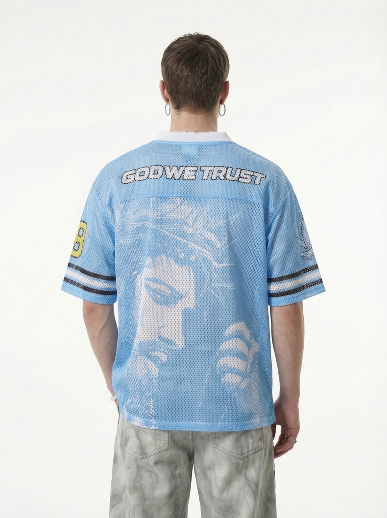 Light blue mesh jersey T-shirt with God We Trust graphic, worn by a model viewed from the back