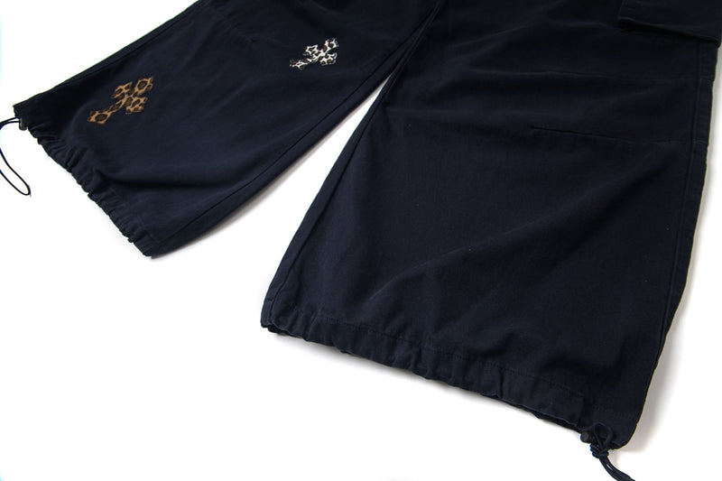Black wide-leg cargo pants hem with drawcord cuff and leopard cross patches