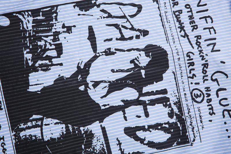 Close-up of bold black graphic print on light blue pinstripe shirt