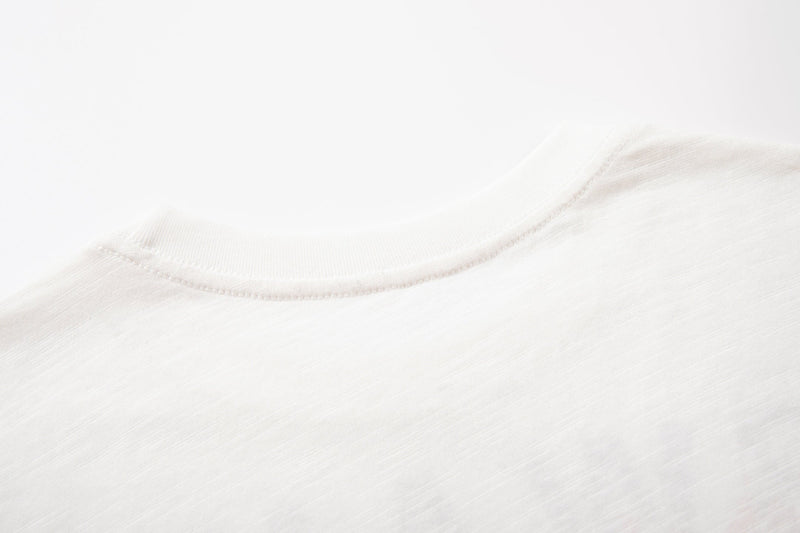 Close-up of a white crew neck t-shirt collar with soft fabric texture and subtle stitching detail
