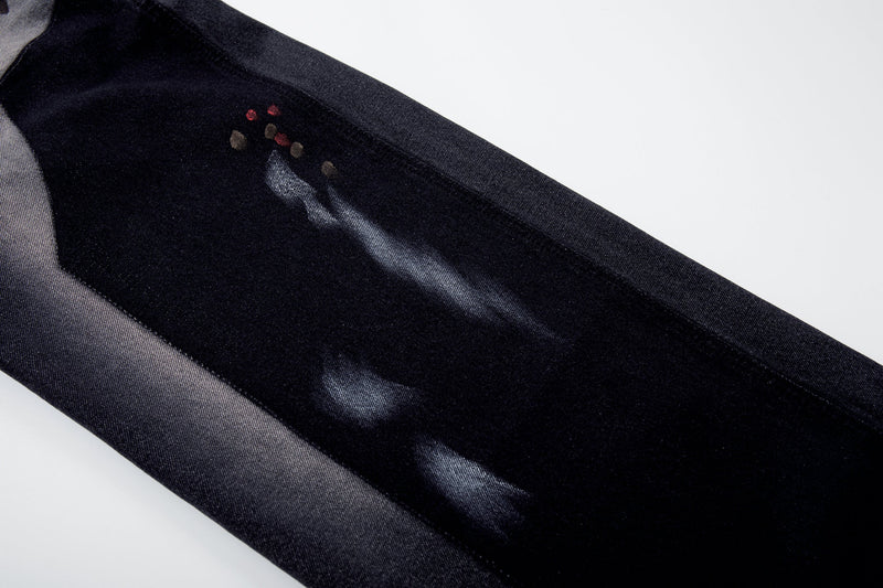 Upper leg close-up showing brushstroke fade and red accent on dark wash jeans