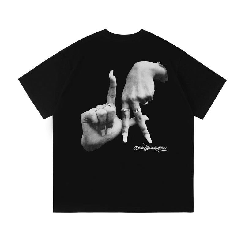 Black oversized tee with a bold grayscale hand graphic and small From Estevan Oriol script on the chest and back graphic area