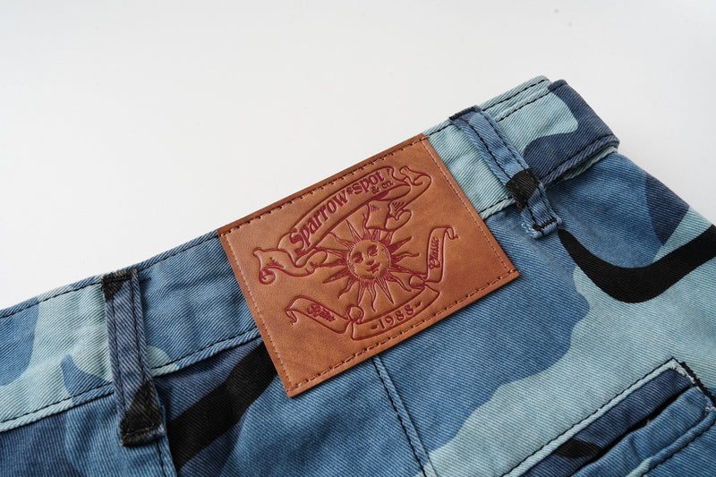 Leather brand patch on the back waistband of blue camouflage cargo shorts
