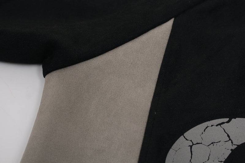 Close-up of beige sleeve panel meeting black body on suede-finish hoodie