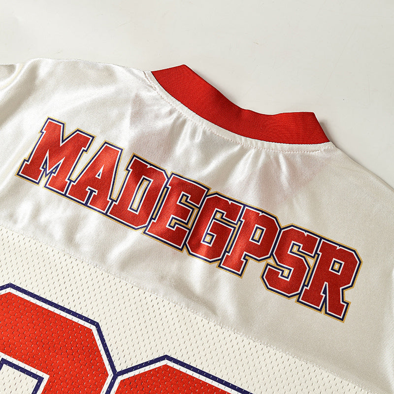White mesh football jersey with red collar and bold MADEGPSR lettering on the back, laid flat on a light surface