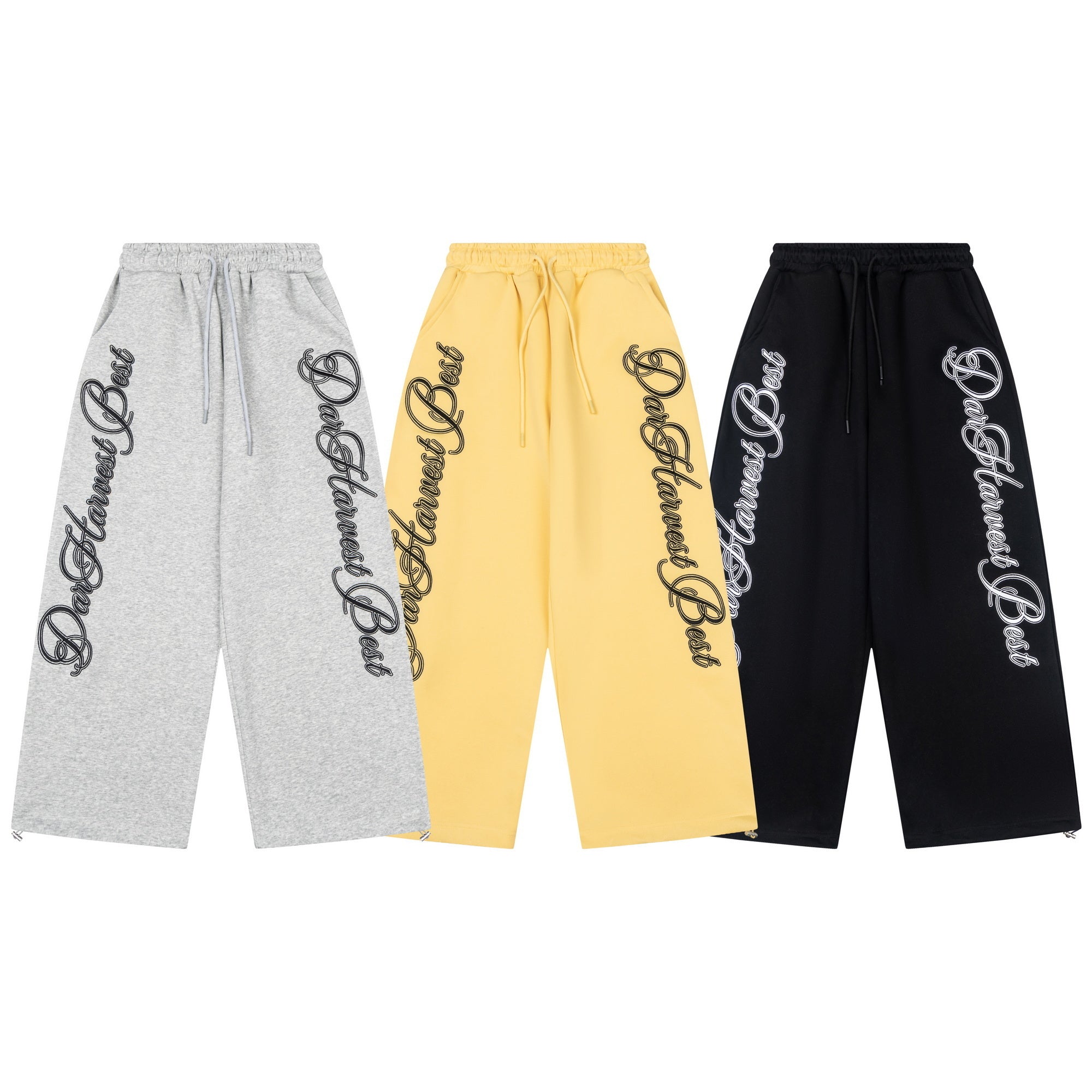 Three wide-leg sweatpants in heather grey, yellow, and black with bold script logo print down both legs