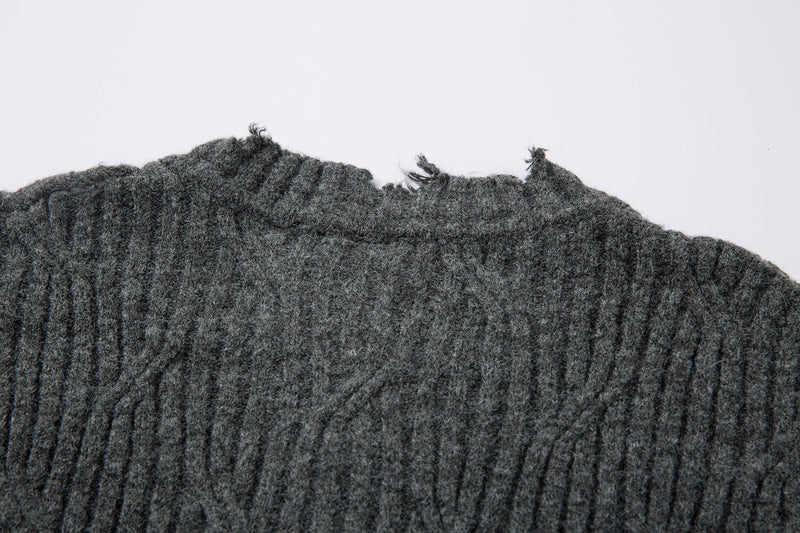 Close-up of charcoal gray ribbed knit at the frayed neckline