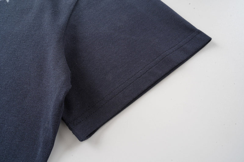 Dark navy graphic T-shirt sleeve with visible hem stitching on a clean white background