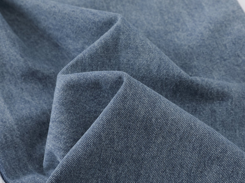 Close-up of blue denim fabric folds and texture