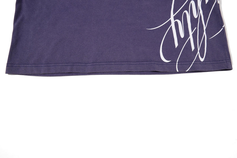 Washed purple vintage streetwear tee with white heritage crest graphic at the hem