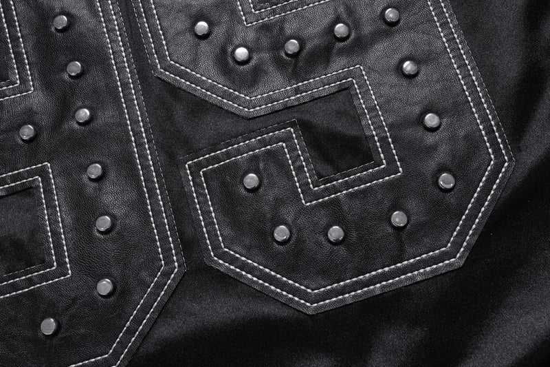 Close-up of leather-like number patch with silver studs and white stitched outline