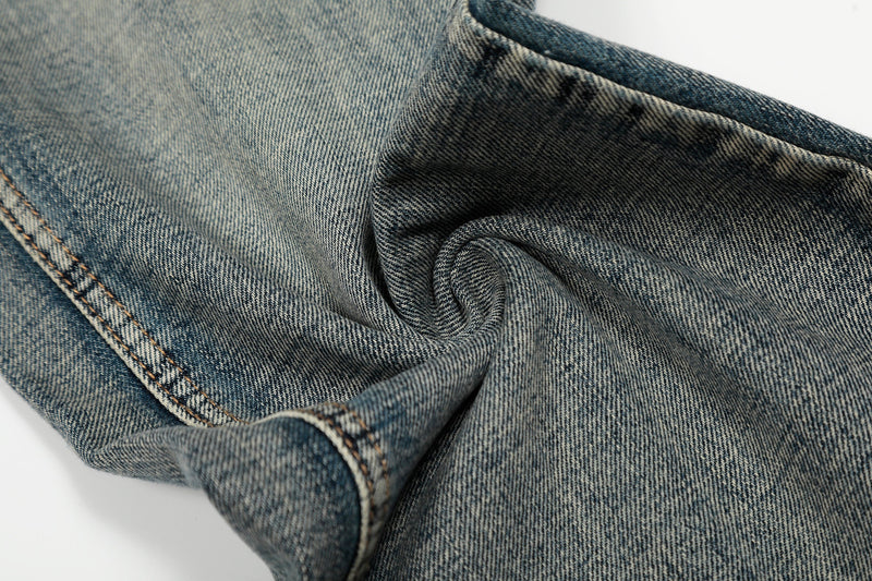 Close-up of denim fabric texture with soft folds and contrast stitching