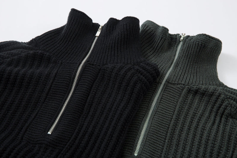 Close-up of two half-zip knit sweater collars with ribbed texture in black and dark green