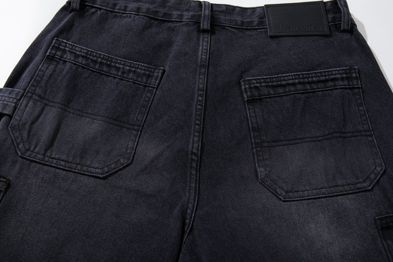 Close-up of the back pockets and logo patch on washed black carpenter jeans