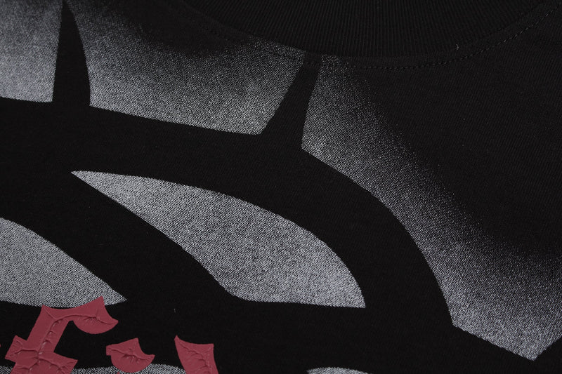 Close-up of a black gothic T-shirt with silver airbrush lettering and red crown of thorns typography detail