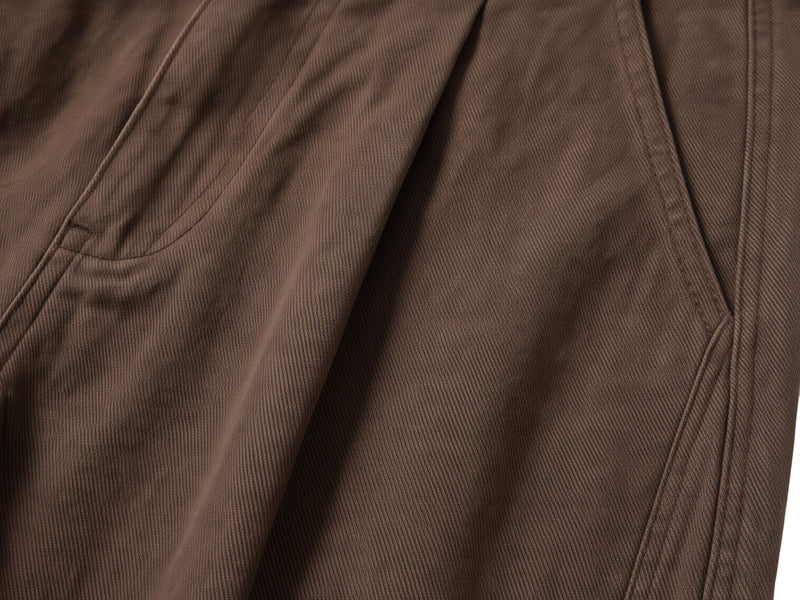 Close-up of brown shorts back pocket and belt loop stitching