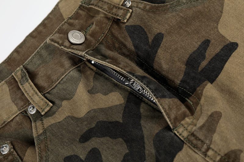 Close-up of camo cargo jeans pocket with zipper detail and metal button