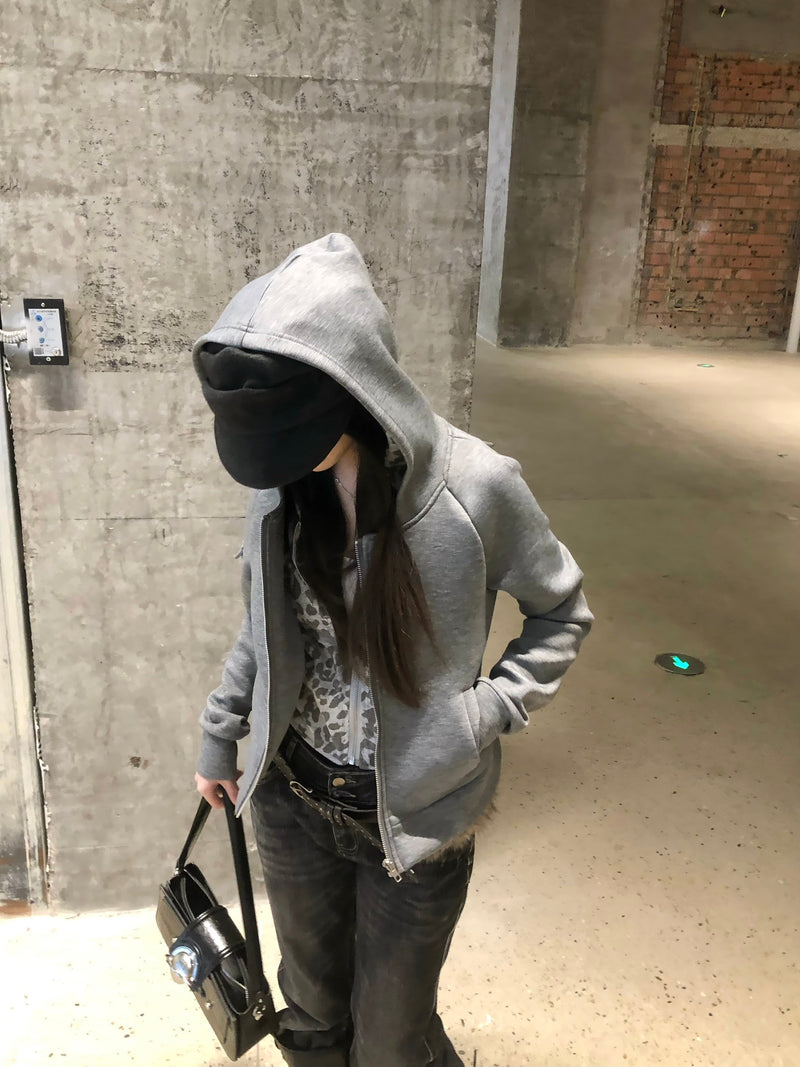 Model wearing grey zip-up hoodie with leopard-print inner layer