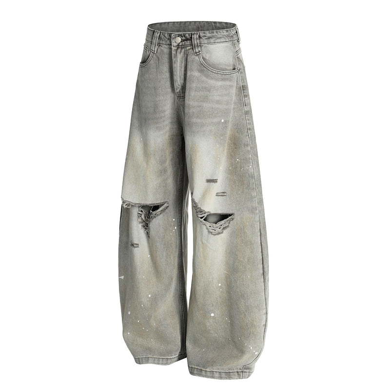 Front view of gray wide-leg jeans with paint splatter, ripped knees, and faded wash
