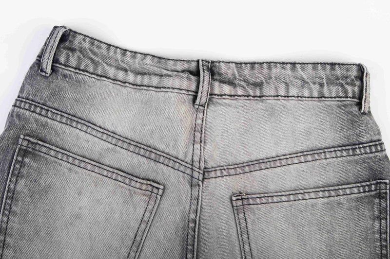 Close-up of the back waistband and pocket tops on washed gray denim