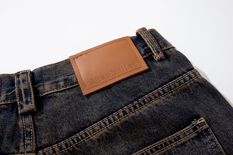 Close-up of the back waistband leather patch on dark-wash jeans