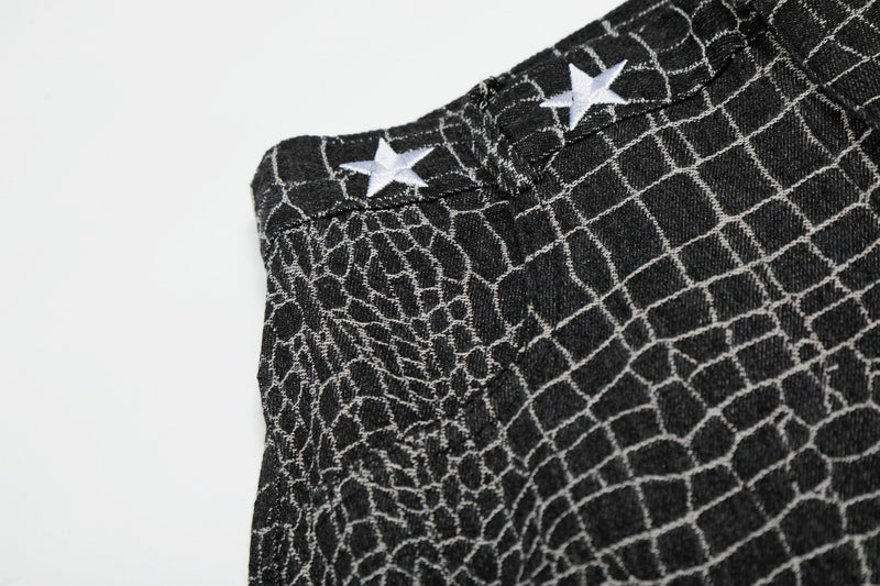 Close-up of black pants side waist with white star embroidery