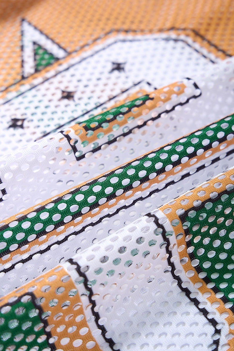 Close-up of a white mesh jersey T-shirt with green and orange graphic trim and stitched detailing