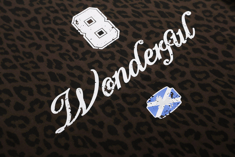 Leopard print graphic tee with distressed white Londres lettering and varsity-style number patches on dark brown fabric