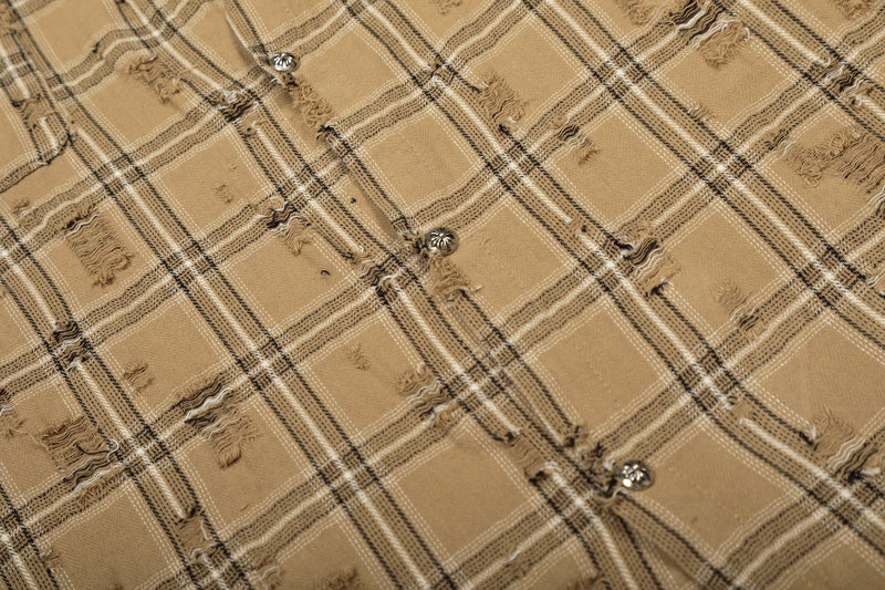 Close-up of tan plaid overshirt fabric with distressing and button detail