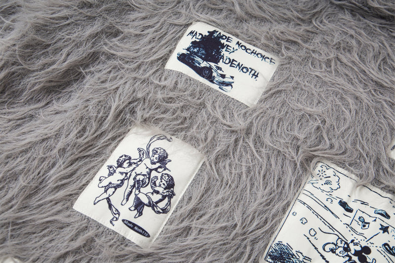 Close-up of gray sweater patches with printed drawings and text