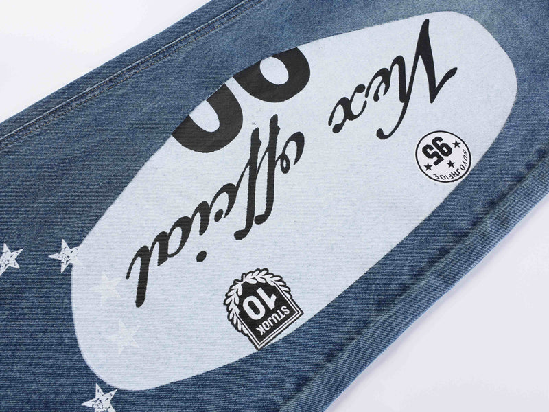 Close-up of blue denim leg with white graphic panel and star print
