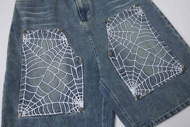 Front of light wash denim shorts with spiderweb pocket panels and hanging straps