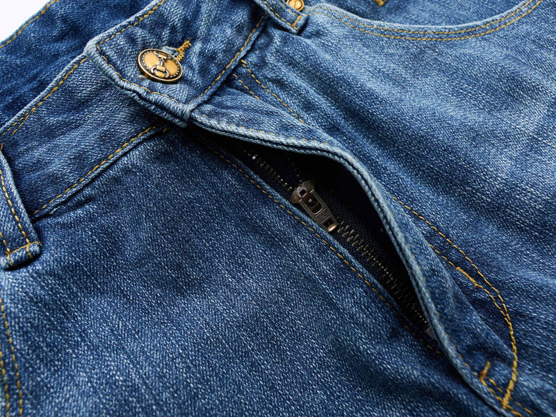 Close-up of the front fly and waistband on blue denim shorts with visible zipper and button