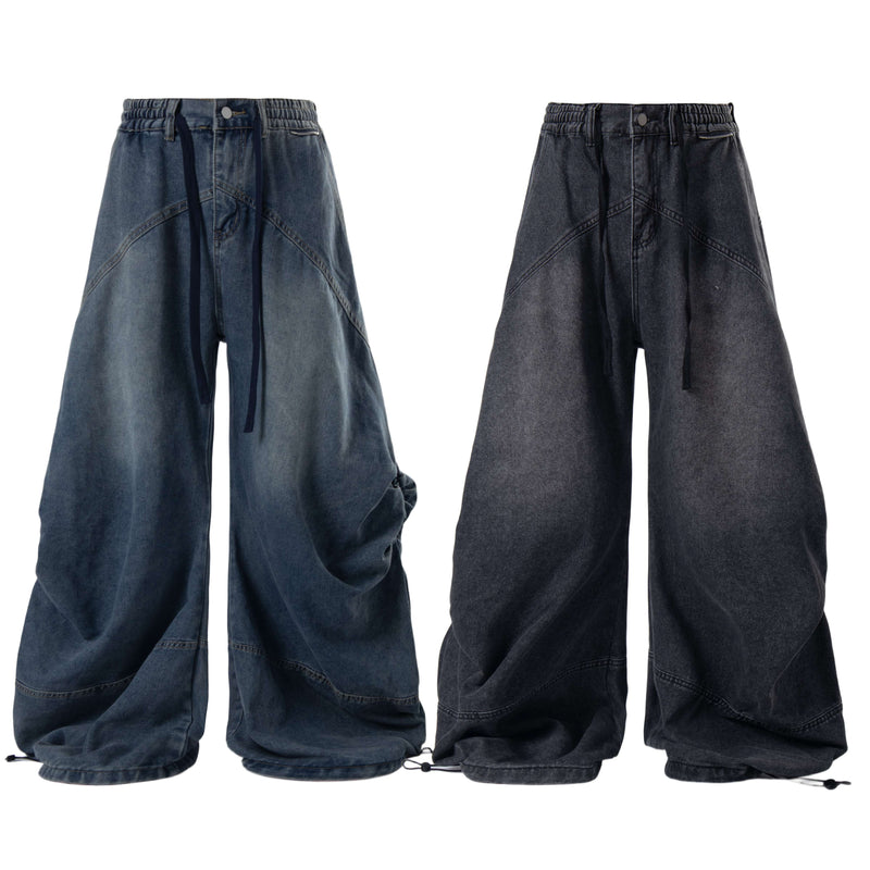 Front view of dark wide-leg layered plaid jeans with loose denim legs and hanging drawstring ties