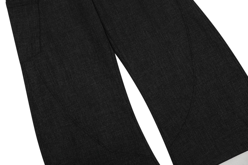 Close-up of black wide-leg pants legs with smooth drape and subtle seam details