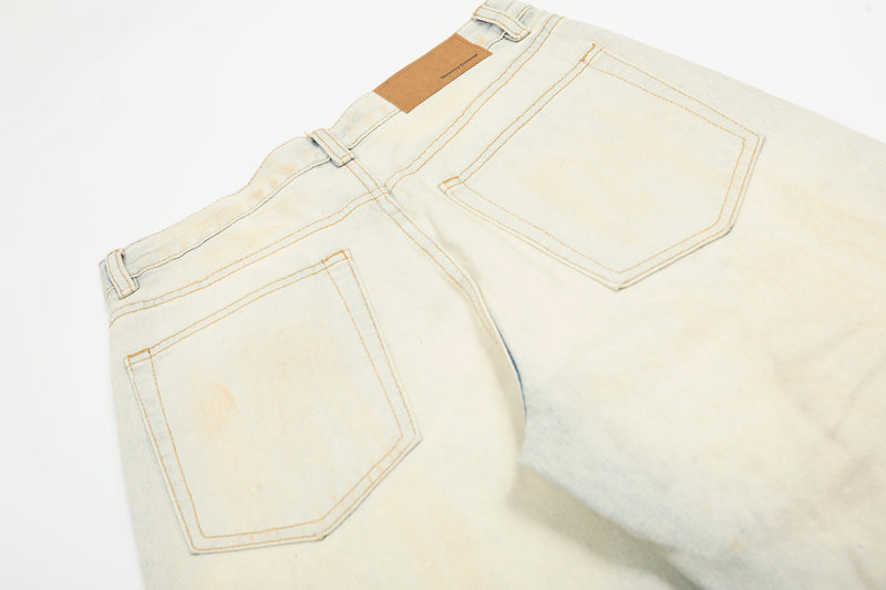 Back pocket detail on cream jeans with tan waistband patch