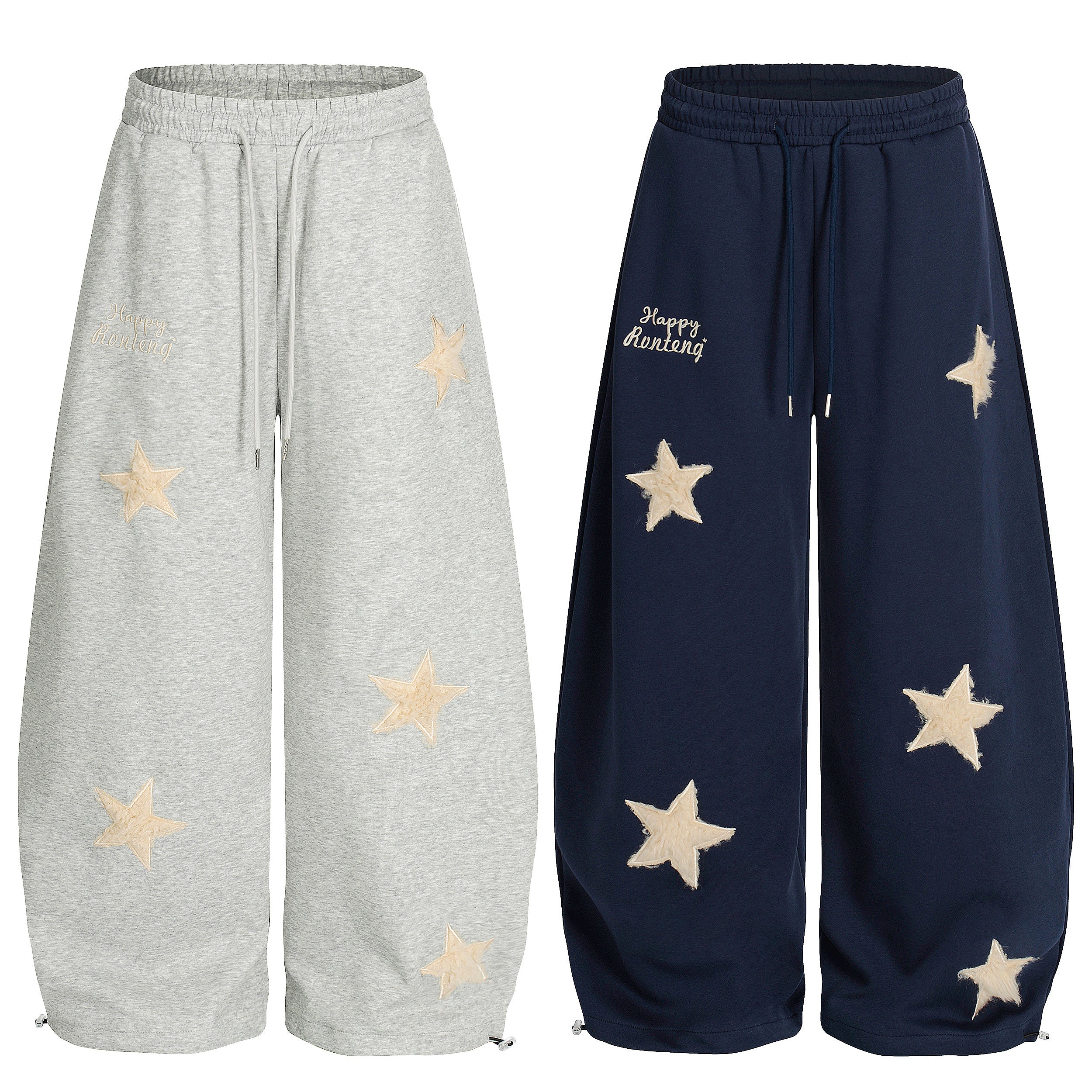Grey and navy wide-leg sweatpants with cream fuzzy star appliqués and embroidered script detail, shown front view