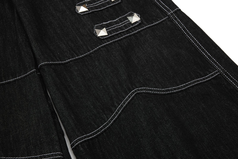 Close-up of back pocket detail on black denim pants with silver studs