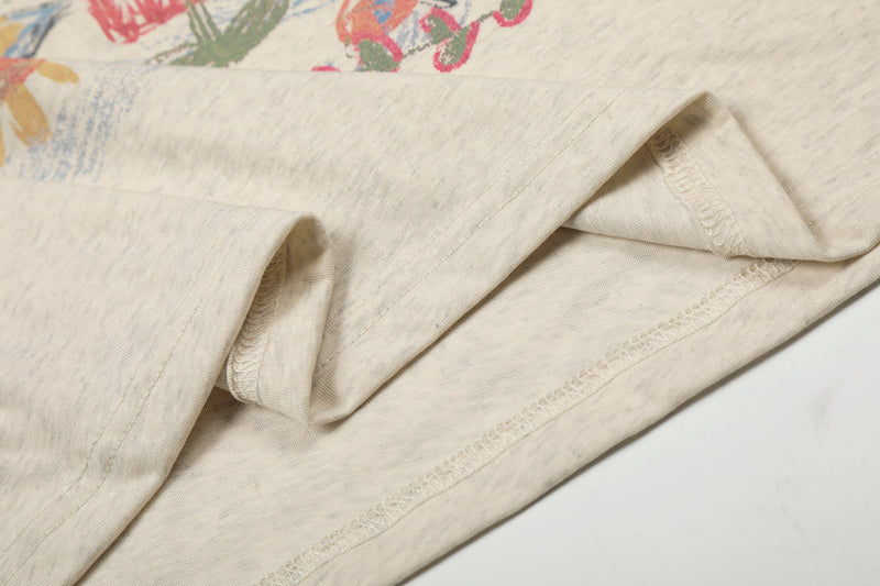 Folded cream long sleeve tee showing sleeve seams and hem stitching