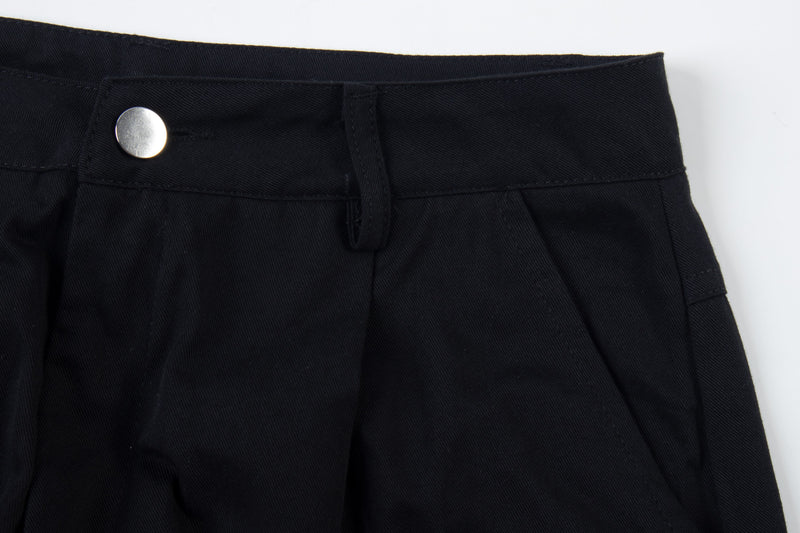 Close-up of black cargo pants waist with silver snap button and twill texture