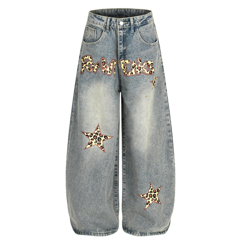 Front view of wide-leg blue barrel jeans with leopard star graphics and distressed wash