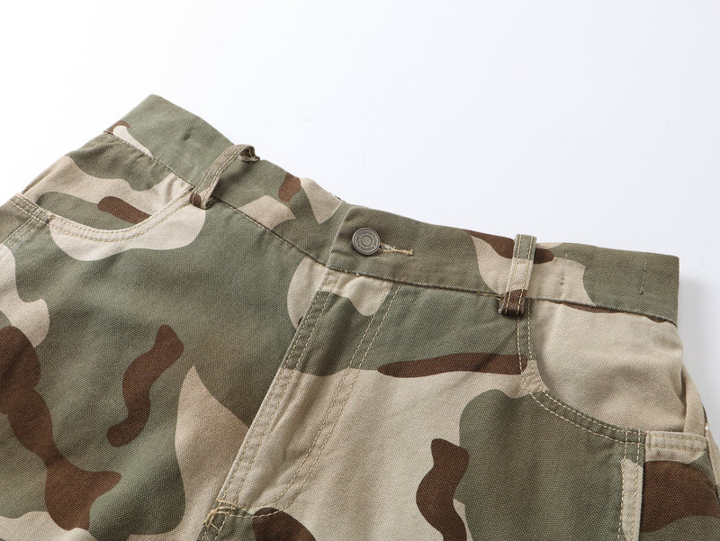 Close-up of camouflage pants waistband with belt loop, pocket edge, and stitched seam