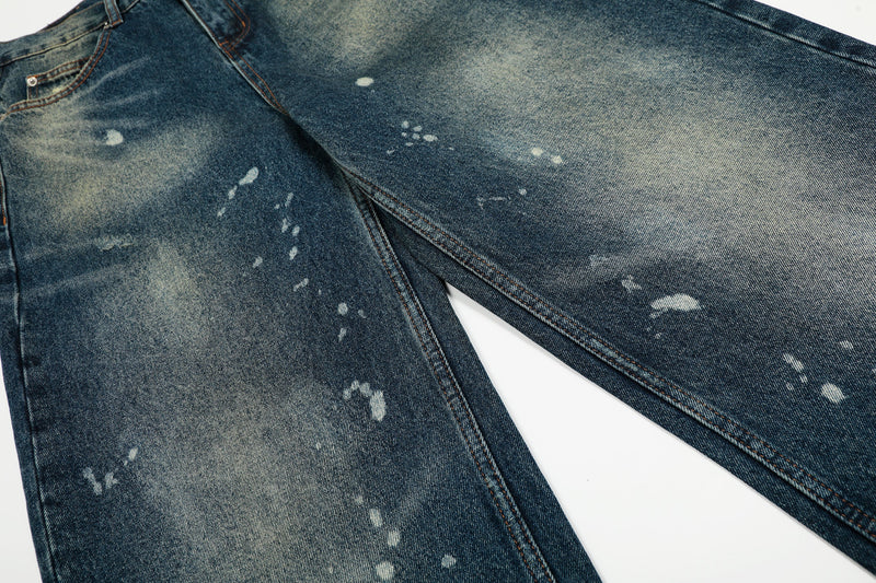 Close-up of the front legs showing paint splatter pattern and faded denim wash