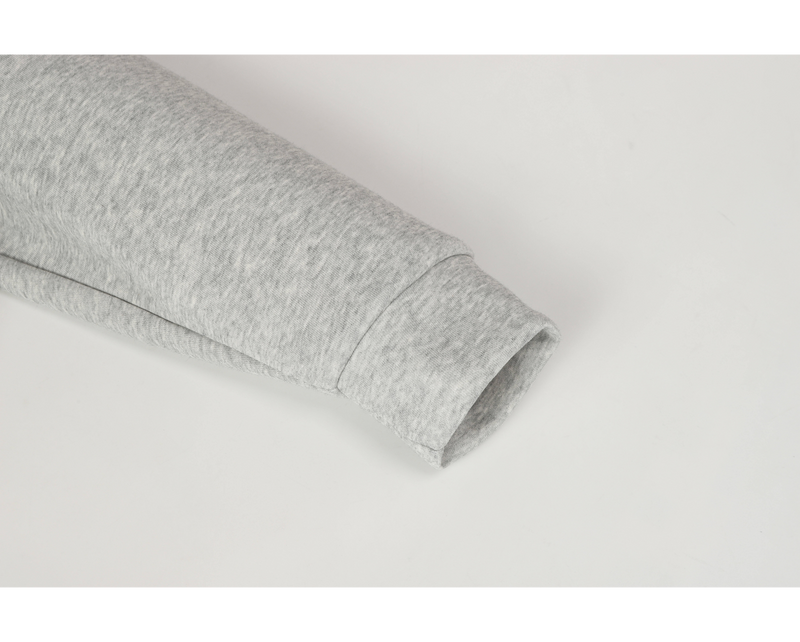Close-up of light gray hoodie sleeve cuff and hem seam