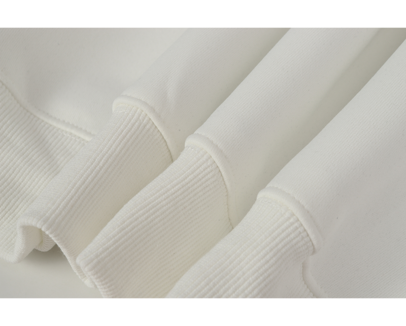 Close-up of three white ribbed sleeve cuffs on the hoodie