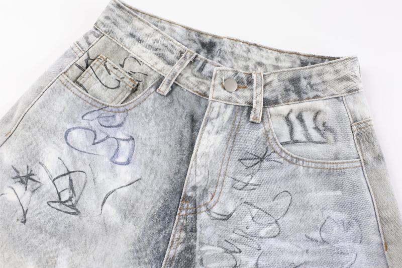 Close-up of front waistband and pockets on gray graffiti-washed denim pants