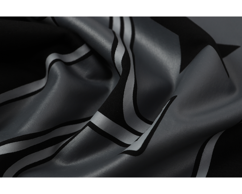 Close-up of gray and black printed fabric with striped camo-style design