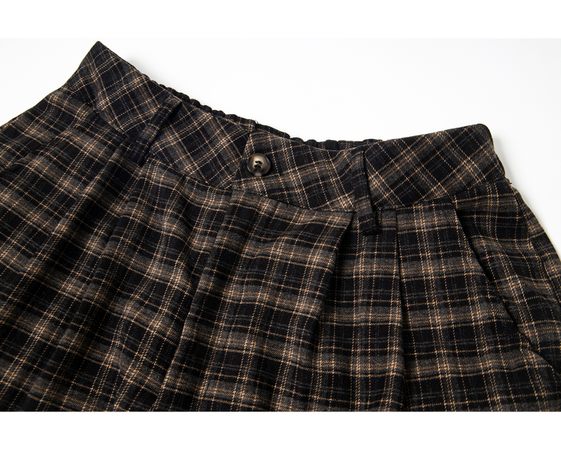 Close-up of plaid waistband with button closure and gathered waist detail