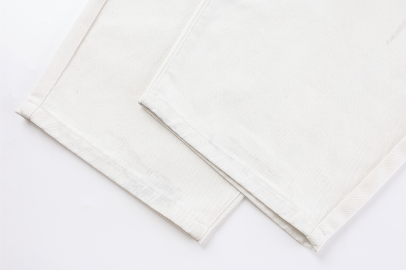 Close-up of wide white denim pant legs at the hem