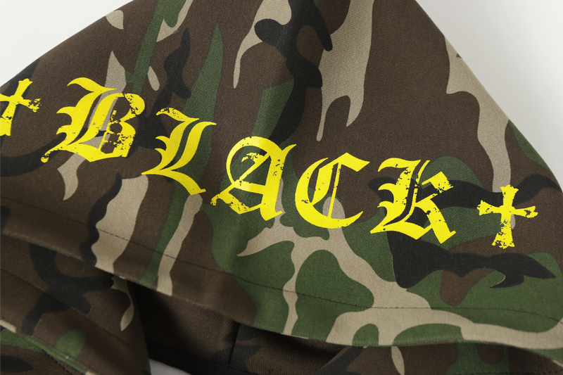 Close-up of yellow gothic BLACK text printed on camo hood fabric